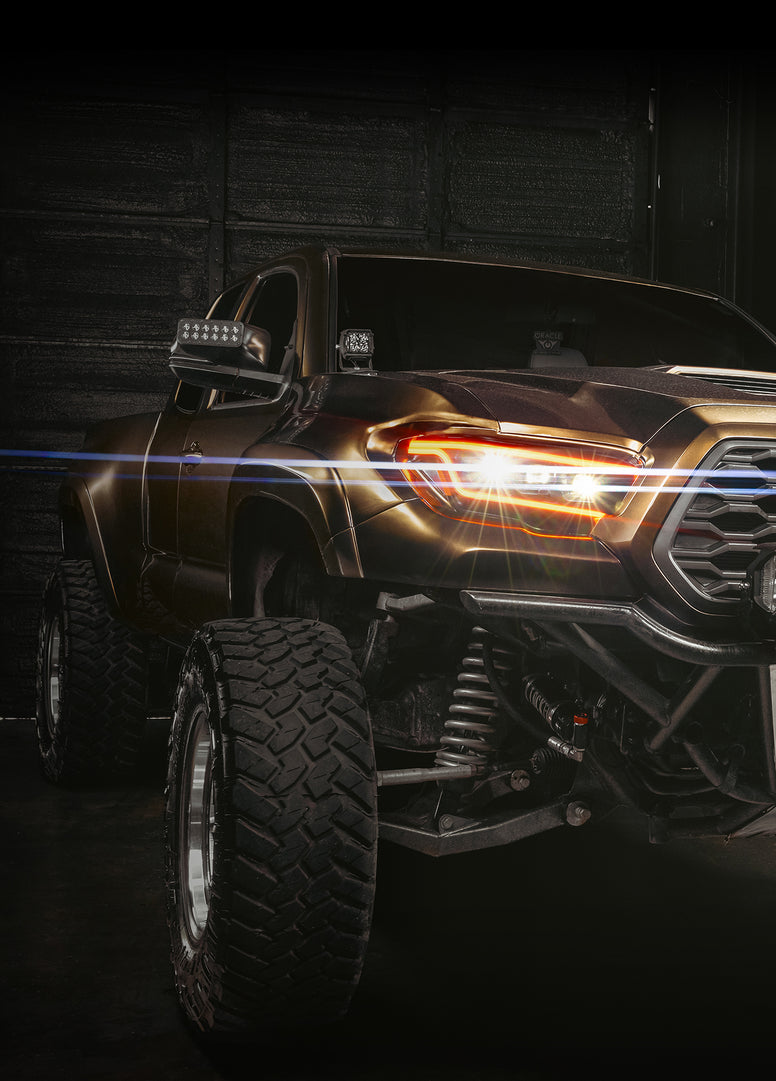 Truck with LED fog lights on in the bumper, showing a low, wide beam on a wet road