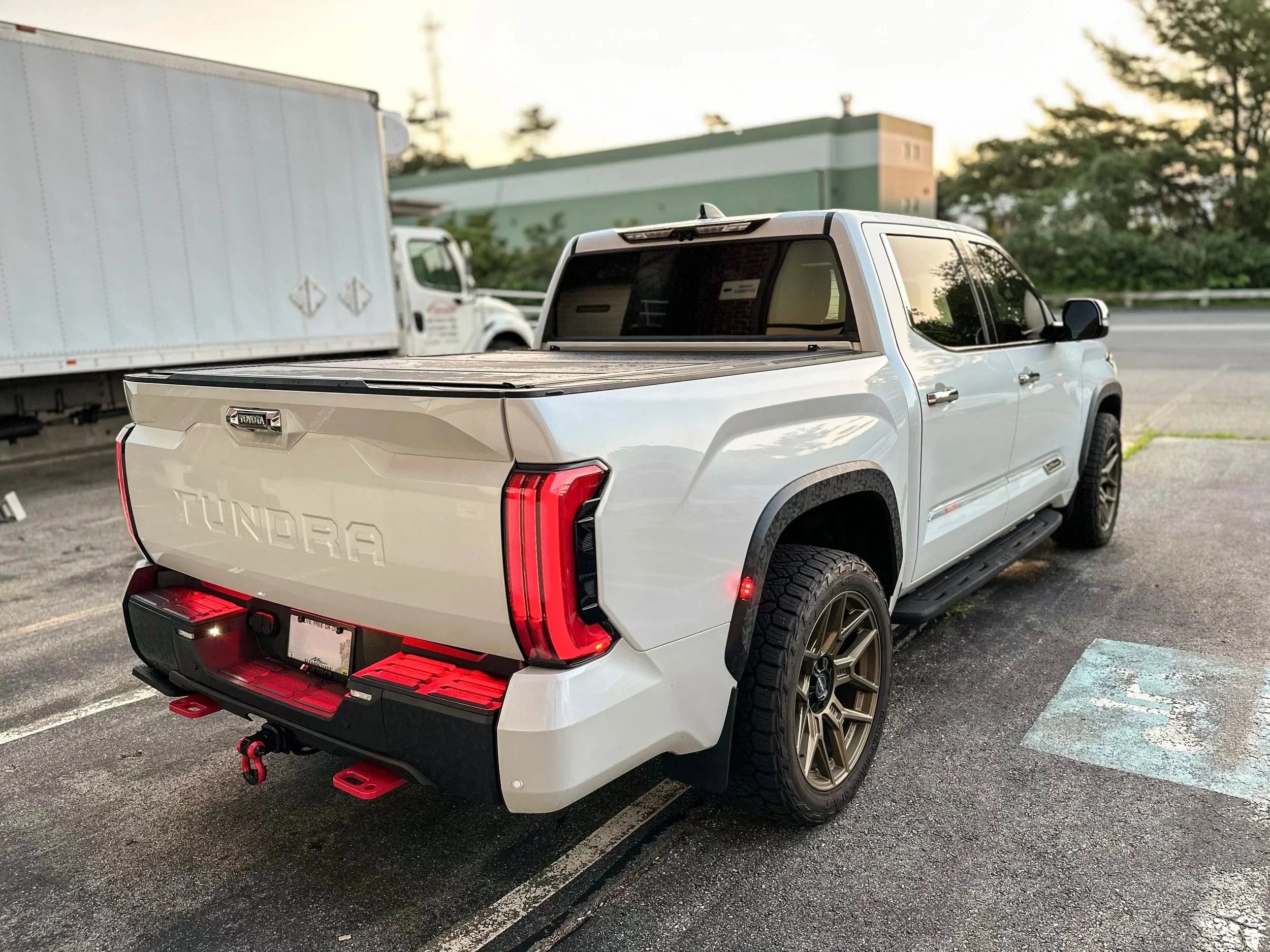 White Toyota Tundra truck with off-road tires and accessories parked outdoors