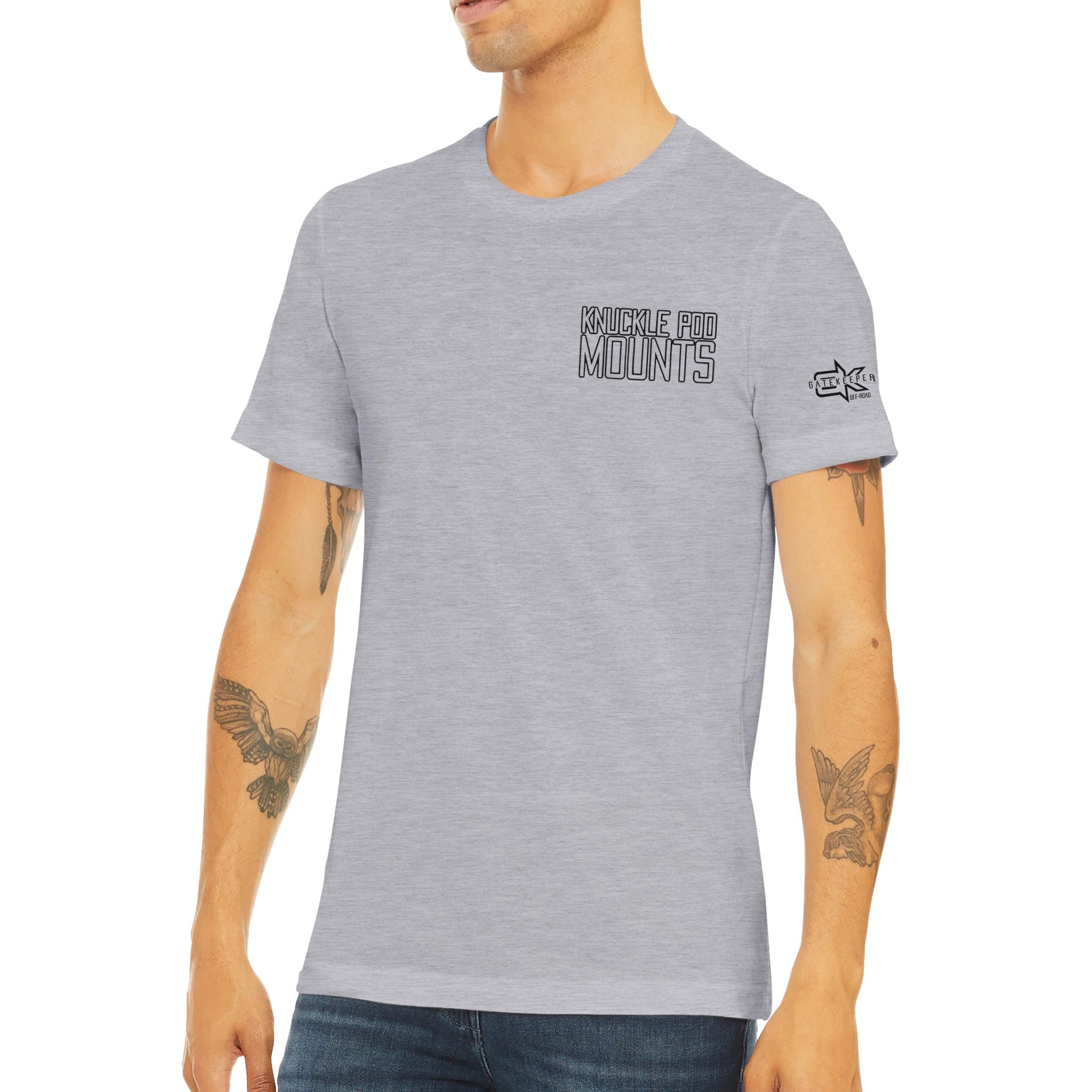 Man wearing light gray Knuckle Pod Mounts t-shirt with sleeve graphic, casual outdoor style