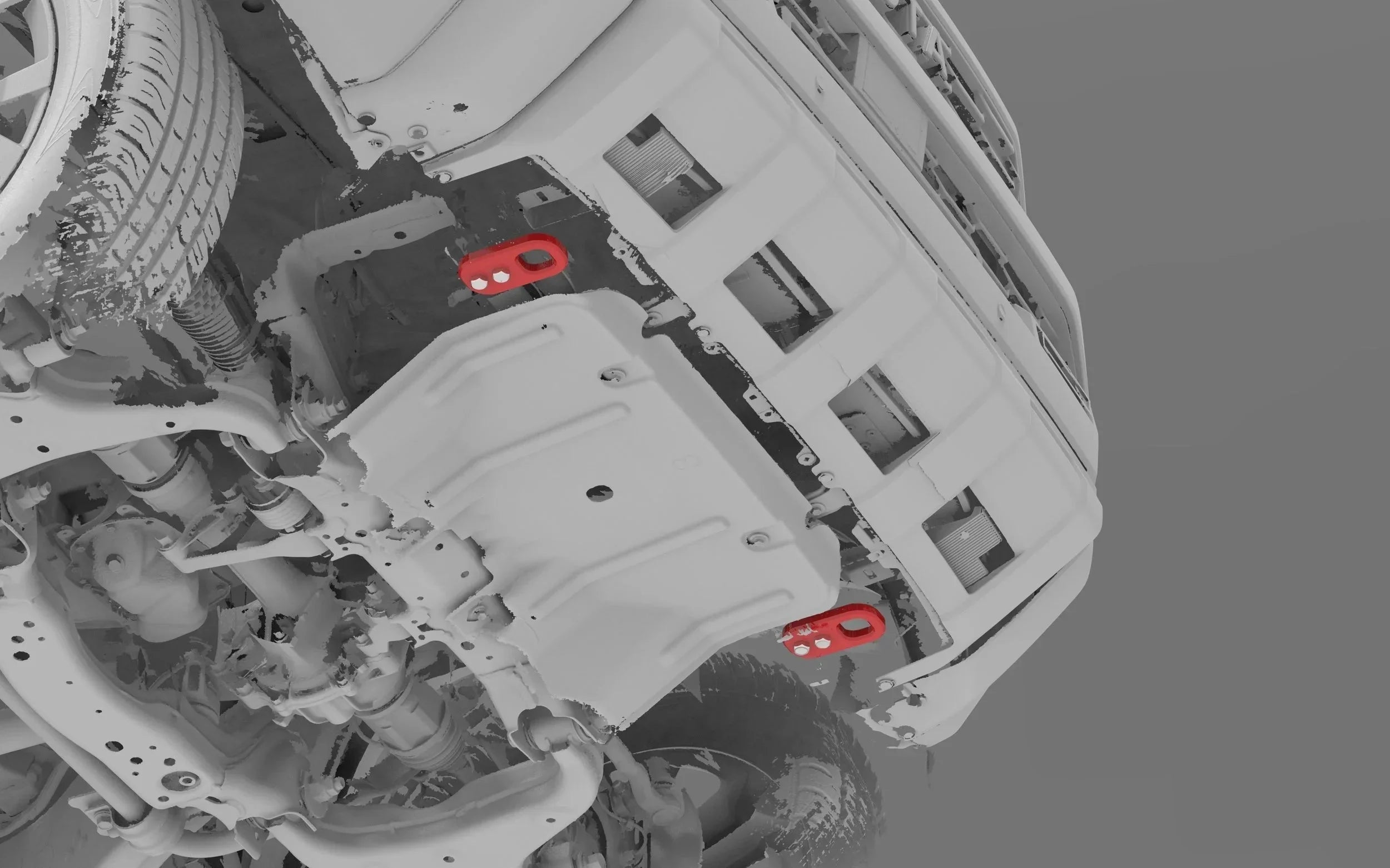 Underside of off-road vehicle showing red rear recovery points and skid plate