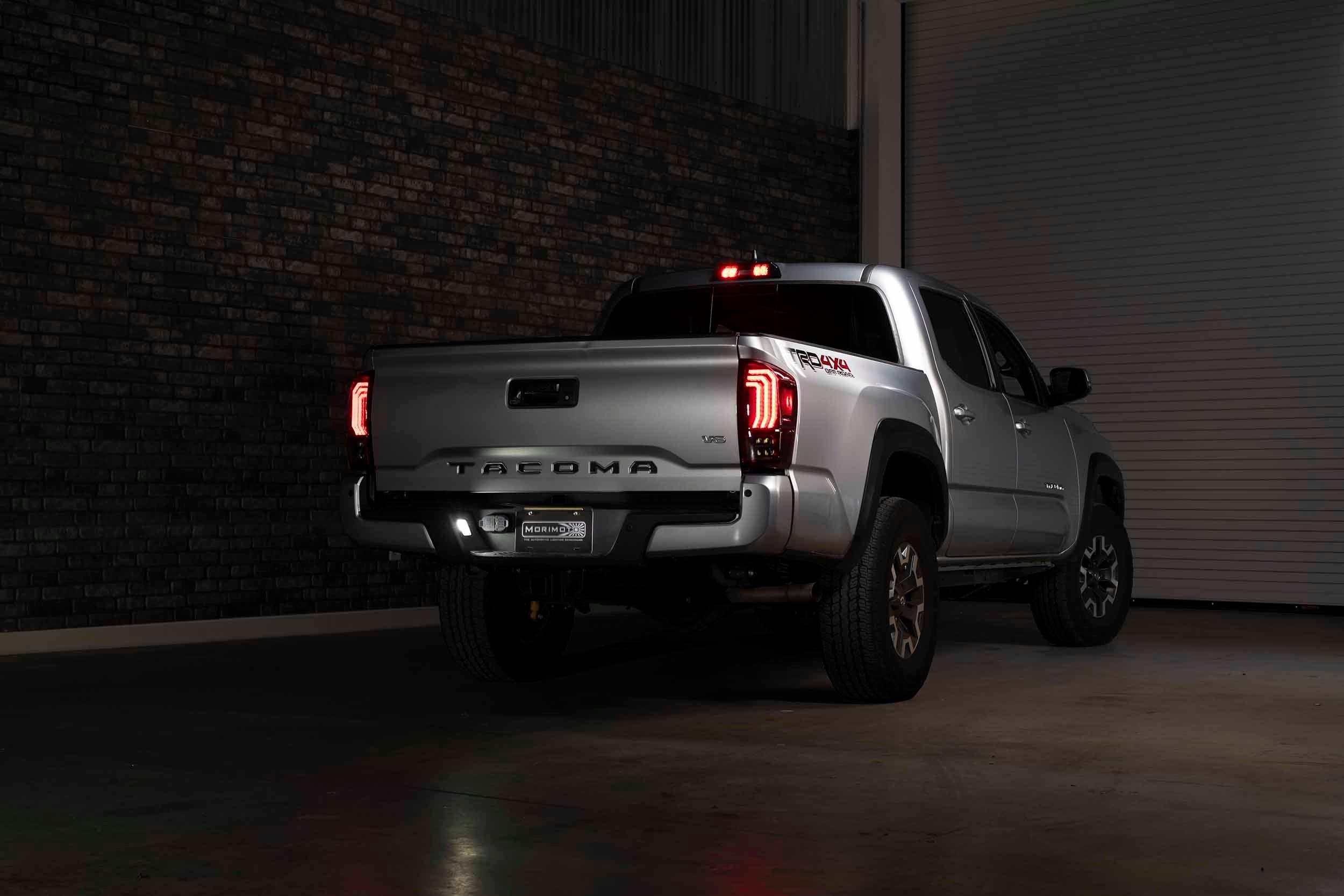 Silver Toyota Tacoma TRD Off-Road pickup with LED tail lights in a dimly lit garage