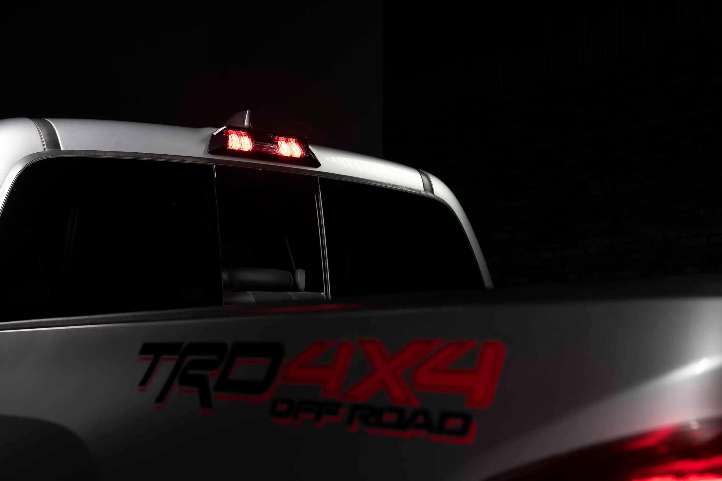 Toyota Tacoma TRD 4x4 Off Road rear cab with illuminated brake light at night