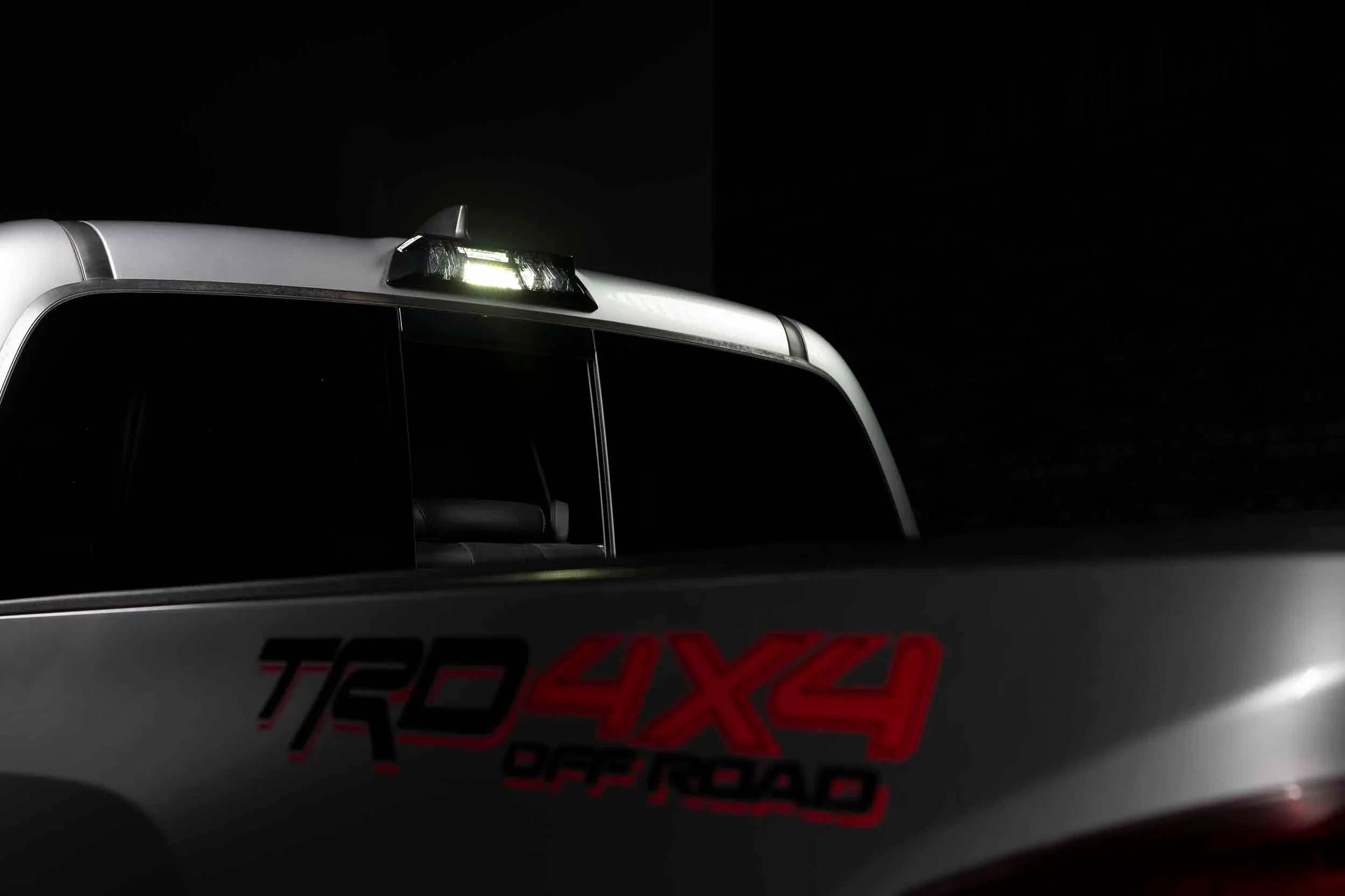 Toyota Tacoma TRD 4x4 Off-Road with illuminated rear cab LED light at night