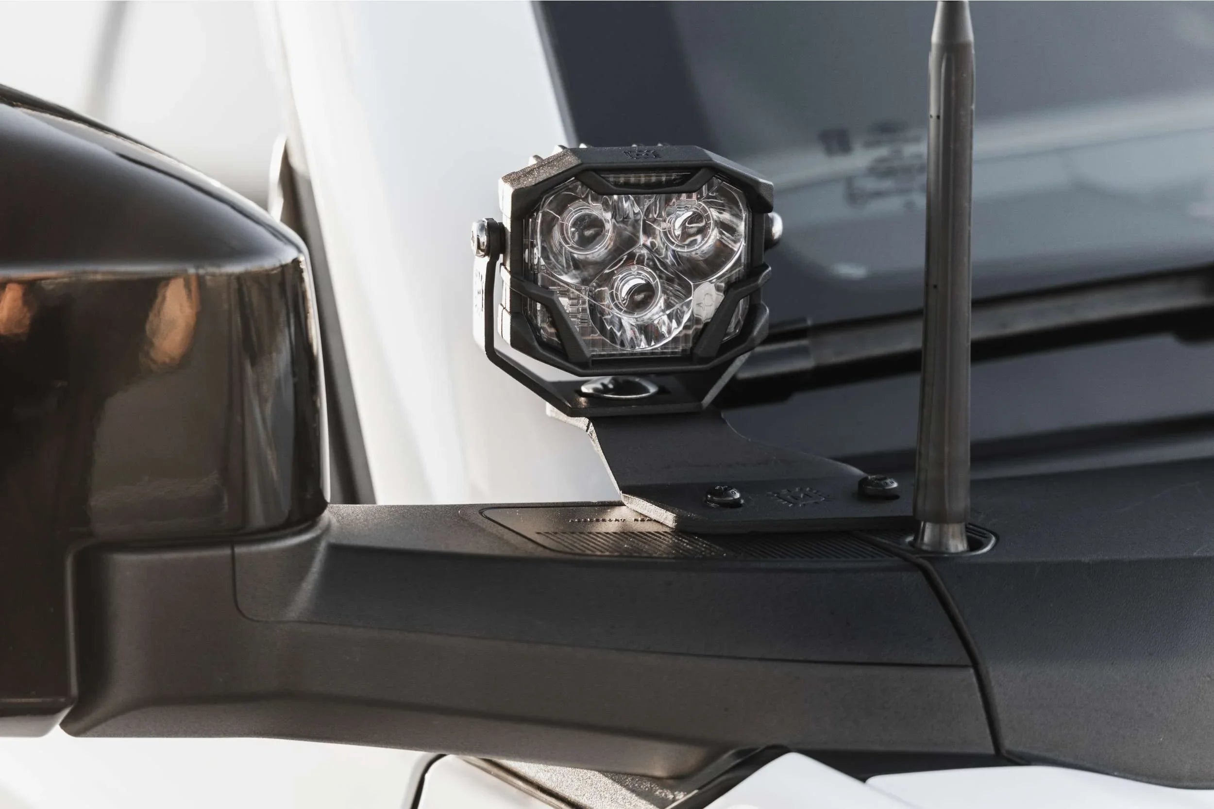 Off-road LED ditch light mounted on vehicle side mirror bracket, close-up view