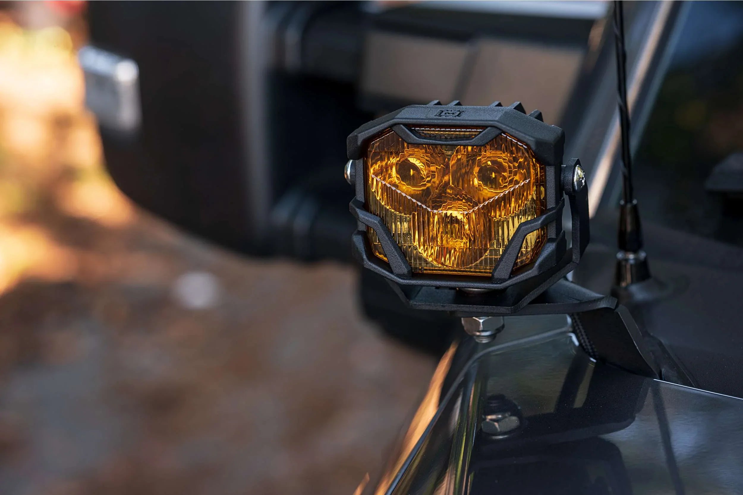 Close-up of amber off-road LED pod light mounted on a vehicle, overlanding accessory
