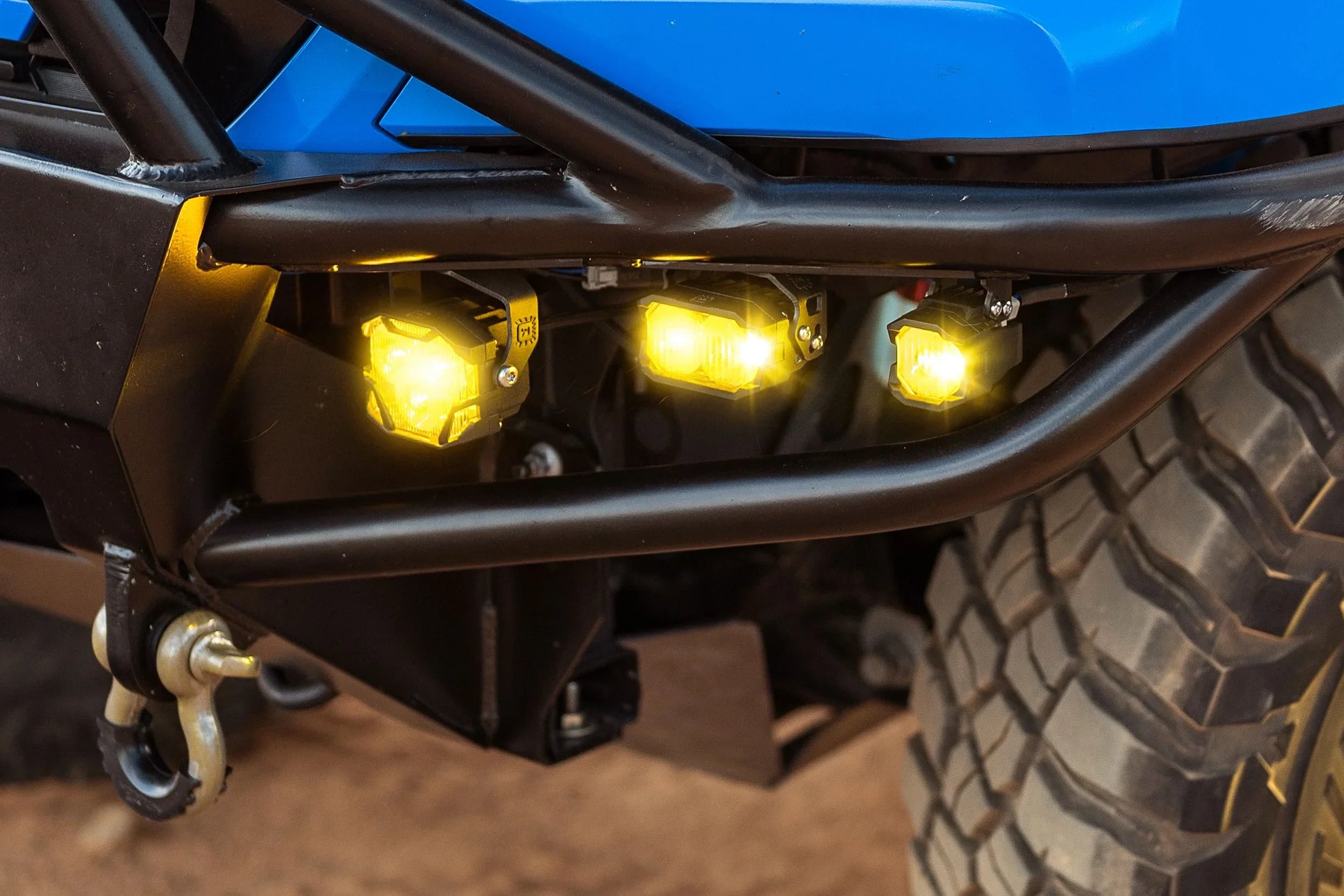 Off-road vehicle bumper with three yellow LED pod lights and all-terrain tire