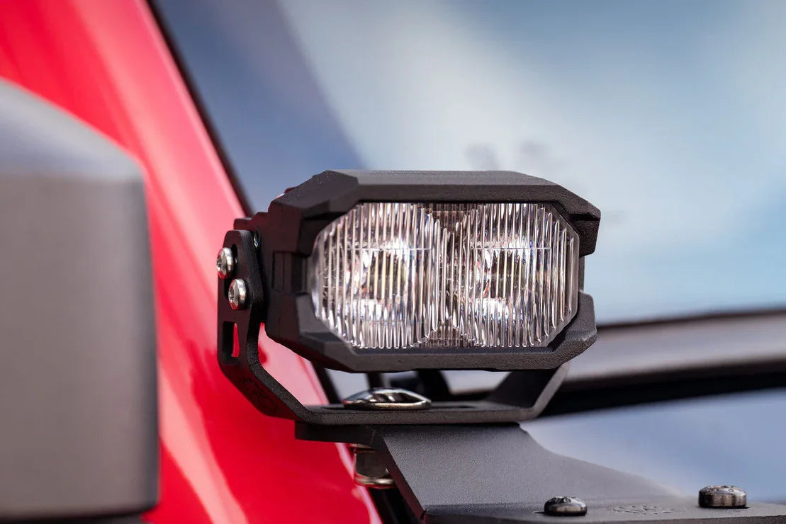 Close-up of off-road vehicle LED pod light mounted on red truck for overlanding