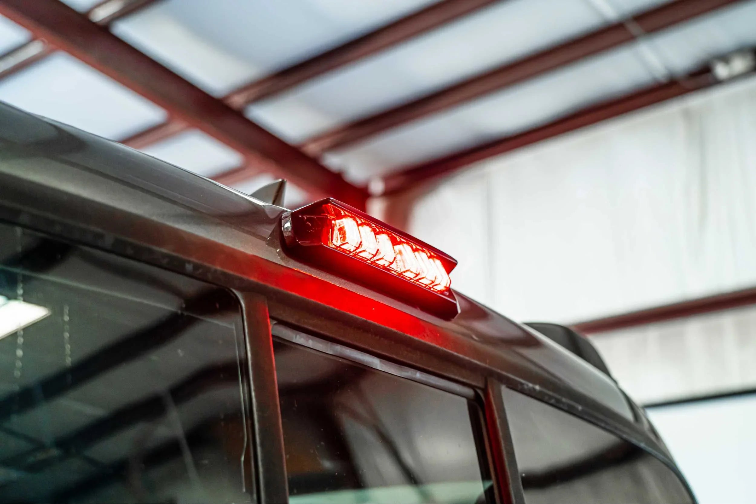 Red LED third brake light installed on rear of off-road vehicle in a garage