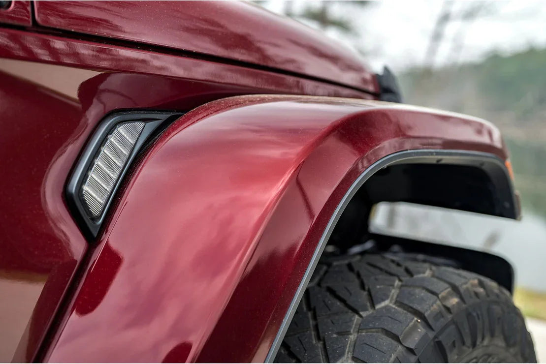 Close-up of red overland vehicle fender with off-road tire and side marker light