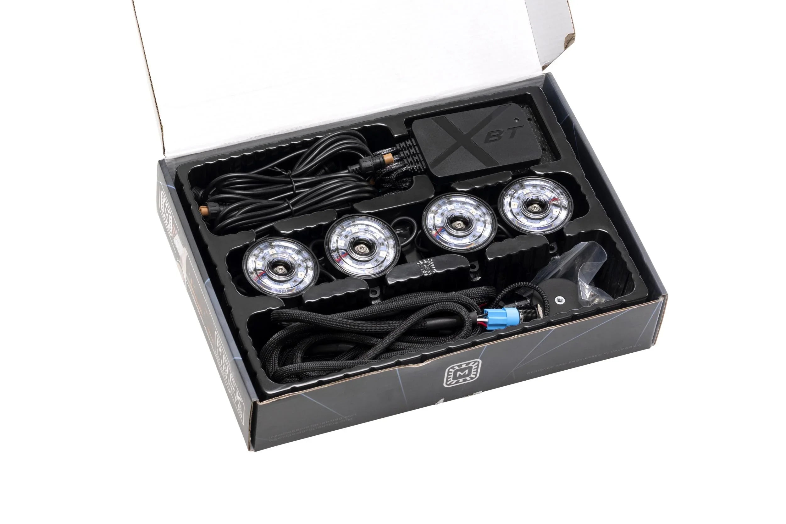 Off-road LED rock light kit with four lights, wiring, and control module in box