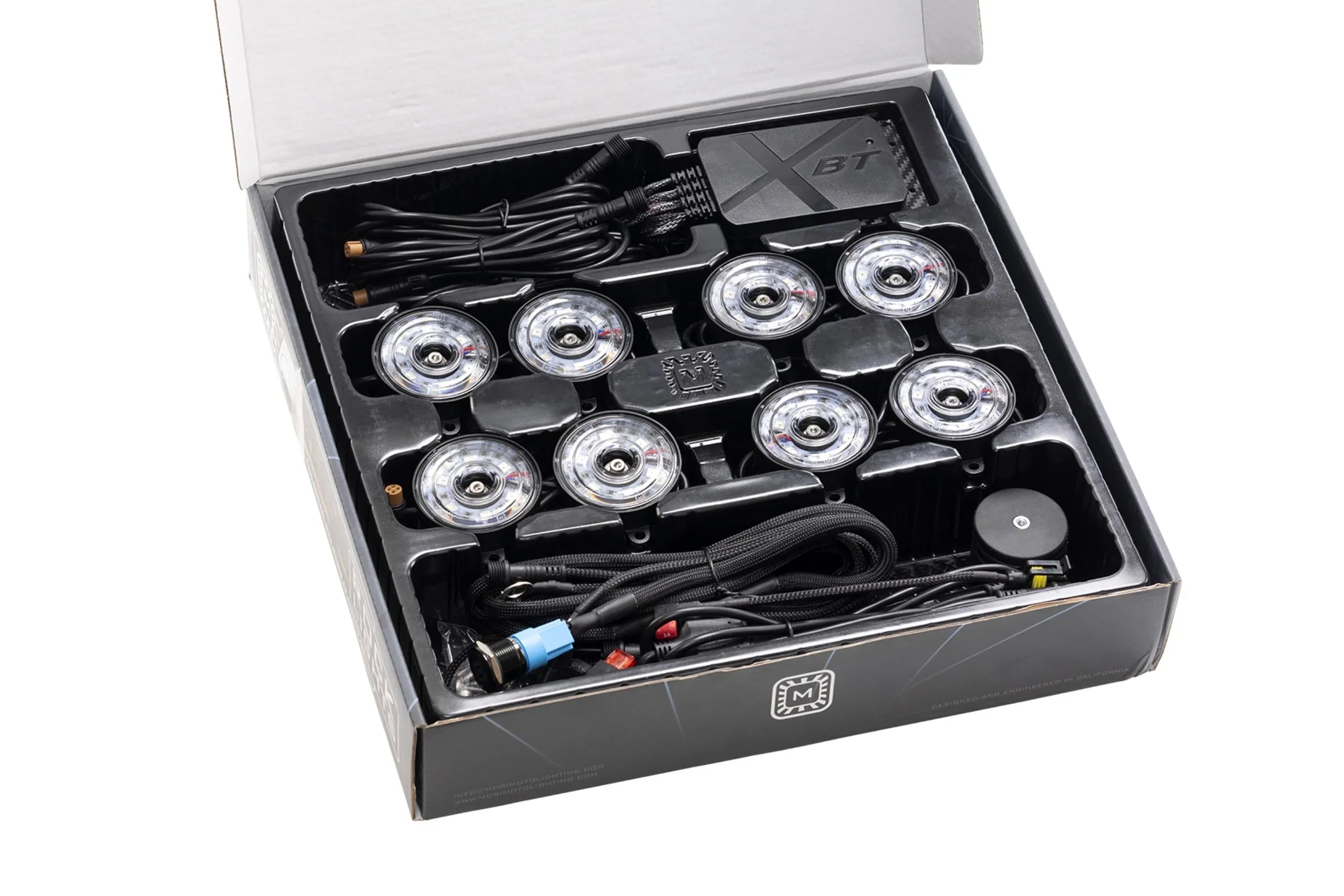 LED rock light kit with eight round lights, wiring, and control module in open box.