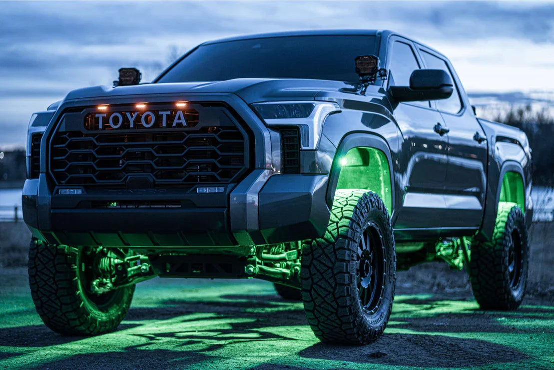 Lifted Toyota Tundra off-road truck with green underglow lights at dusk