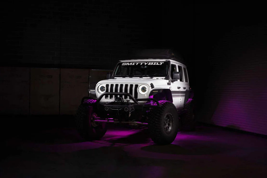 White Jeep Wrangler with off-road upgrades and Smittybilt accessories under purple lights