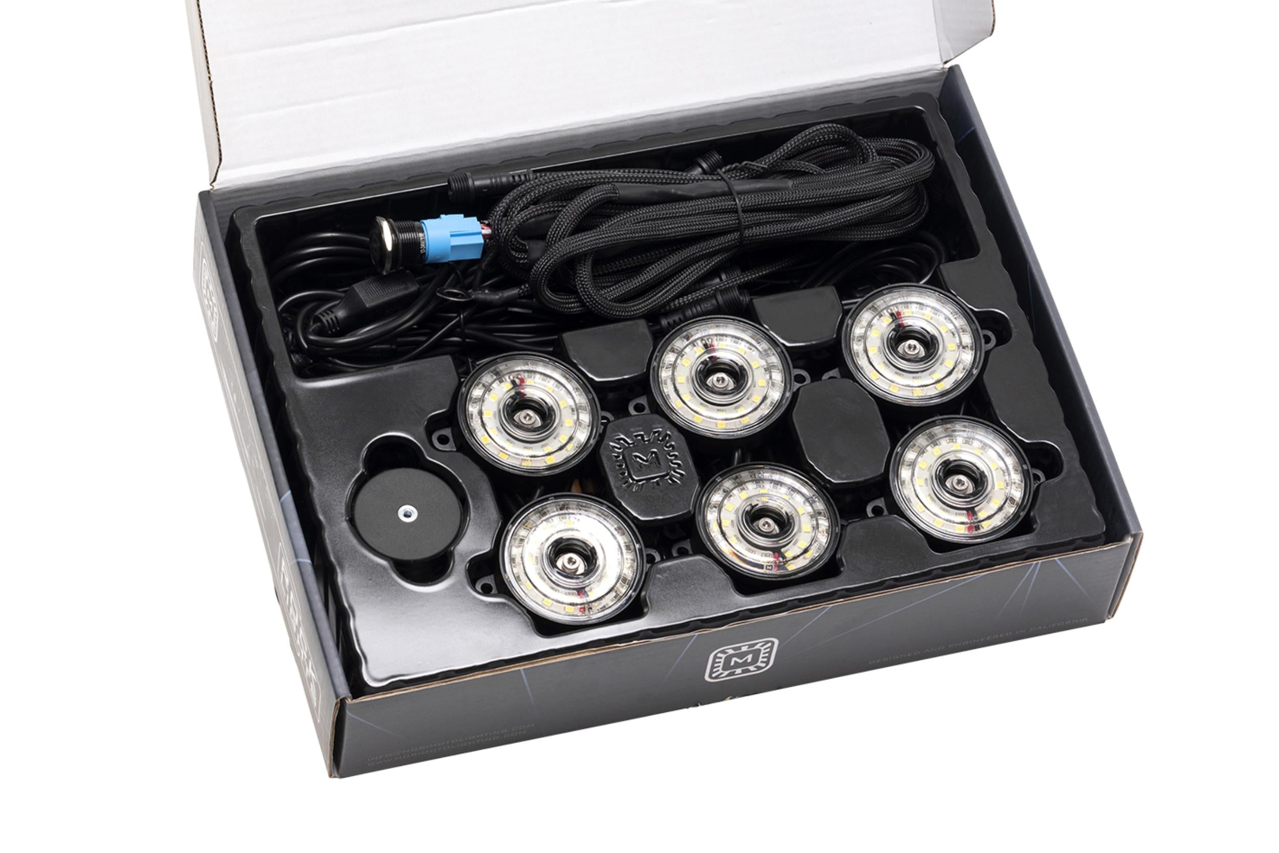 Vehicle LED rock light kit with wiring harness in open packaging, ideal for off-road lighting.