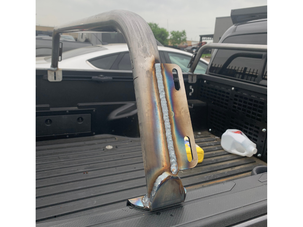 Welded metal overland bed rack mount installed in a truck bed for expedition gear