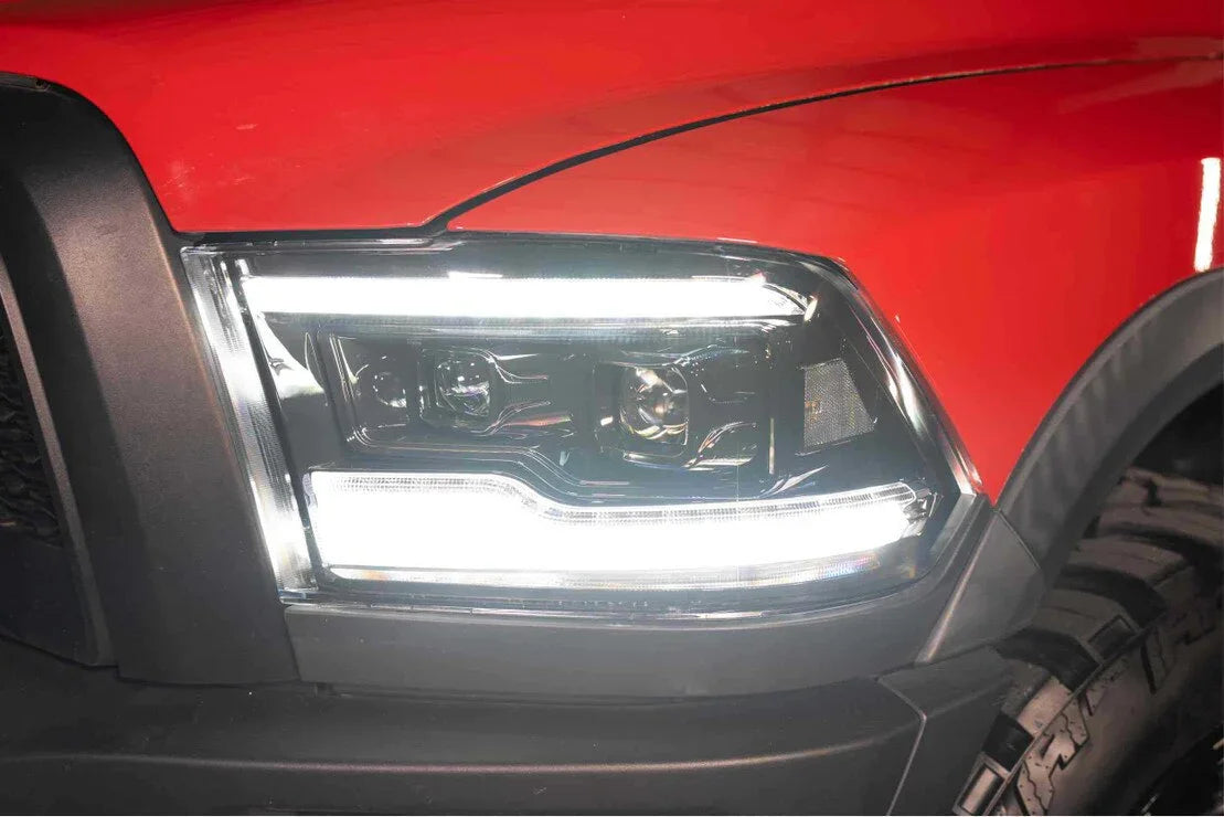 Close-up of LED headlights on a red Dodge Ram truck with off-road tire