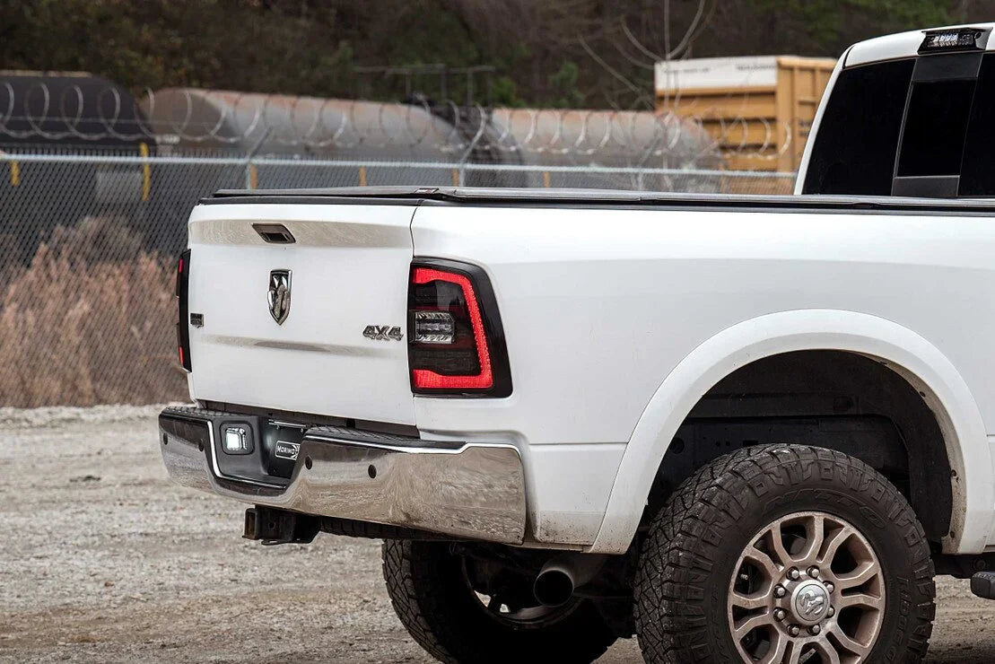 White Dodge Ram pickup truck rear with off-road tires and aftermarket tail lights