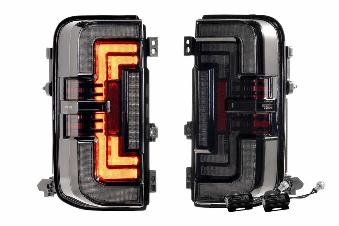 Pair of aftermarket LED tail lights for Toyota Tacoma, black housing with red sequential turn signals