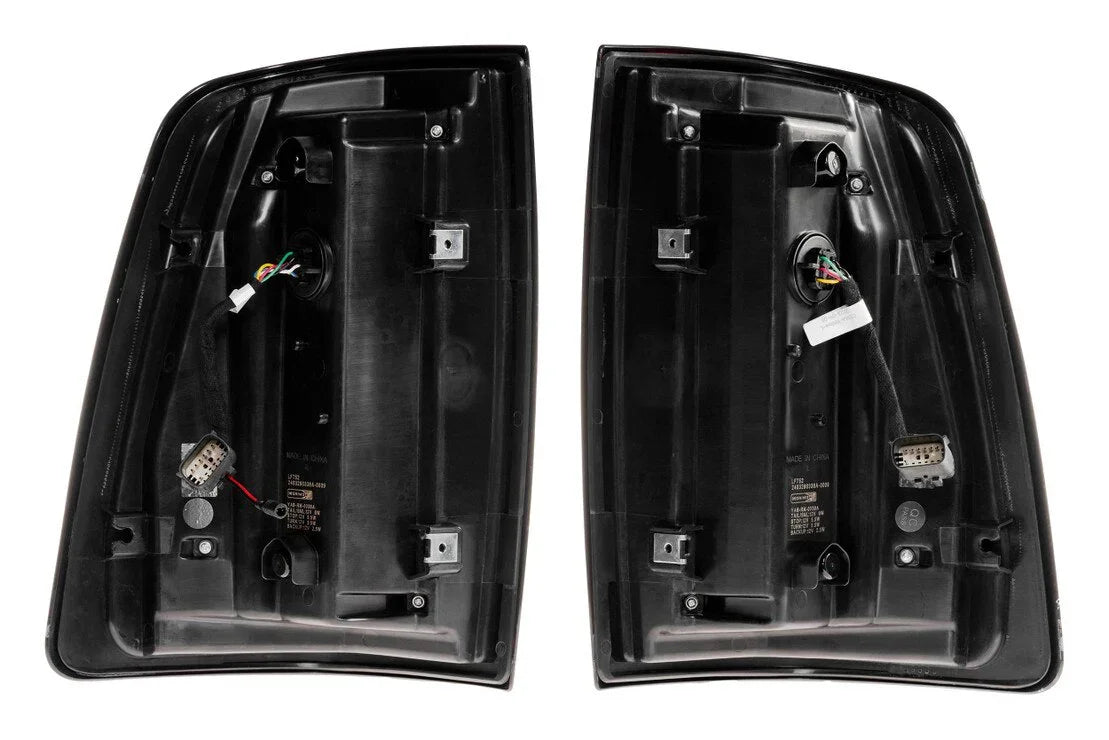 Pair of black aftermarket tail light housings with wiring harnesses for off-road vehicles