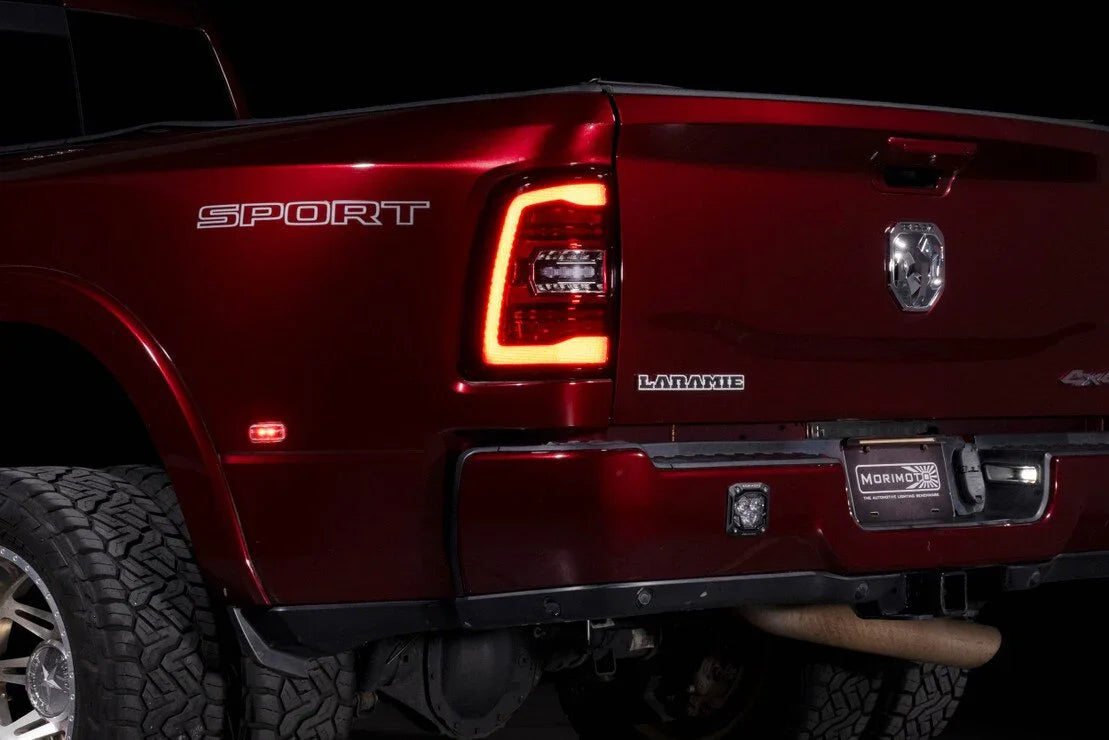 Closeup of red RAM truck rear, featuring illuminated LED tail light and off-road tire.