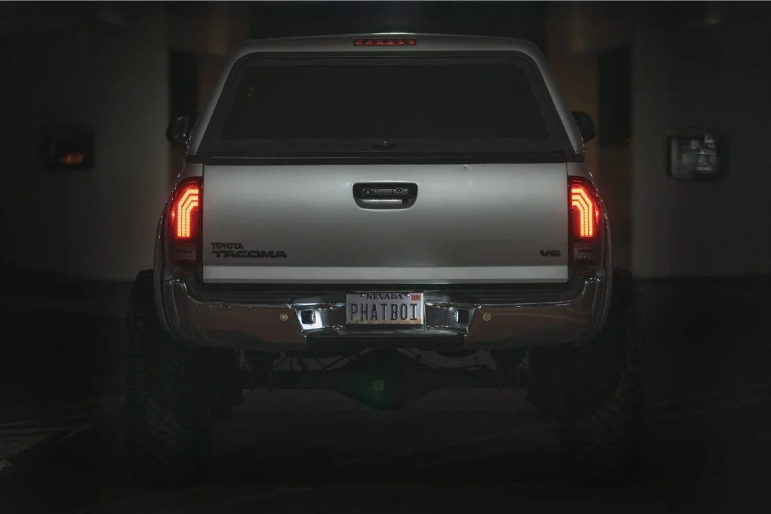 Rear view of a Toyota Tacoma V6 truck with custom taillights in a dimly lit garage