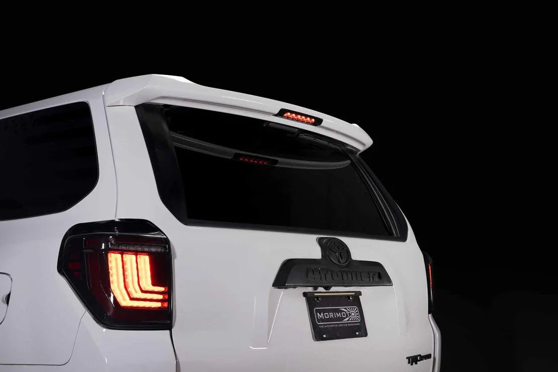 White Toyota 4Runner rear view showcasing LED tail lights, rear spoiler, and Morimoto accessories