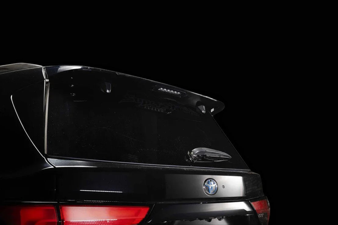 Toyota SUV rear hatch with roof spoiler, rear wiper, and taillight, black background