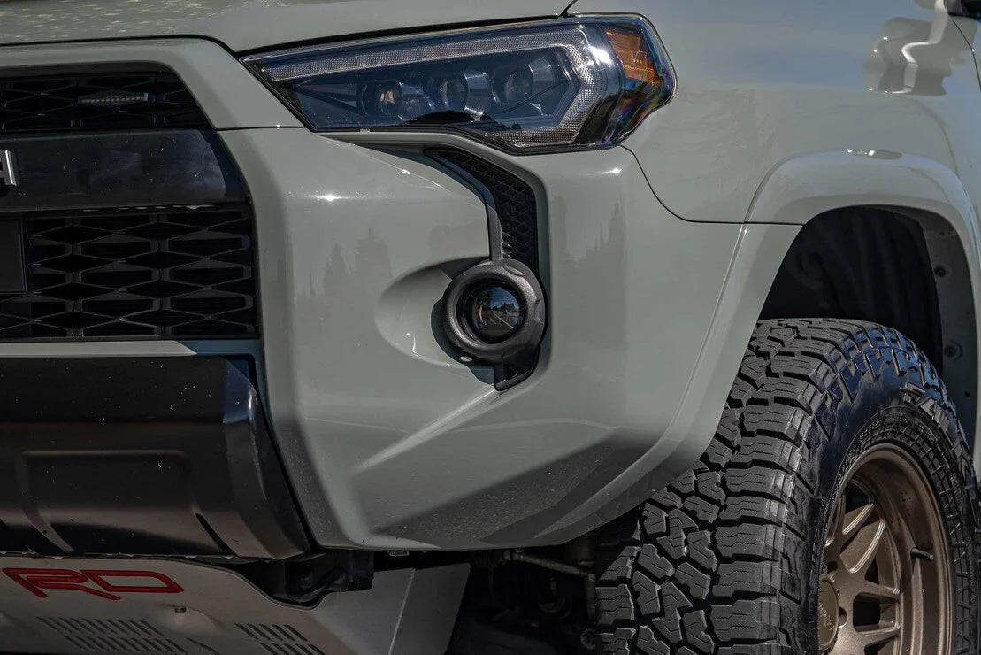 Close-up of Toyota 4Runner front headlight, white LED fog light, and all-terrain tire