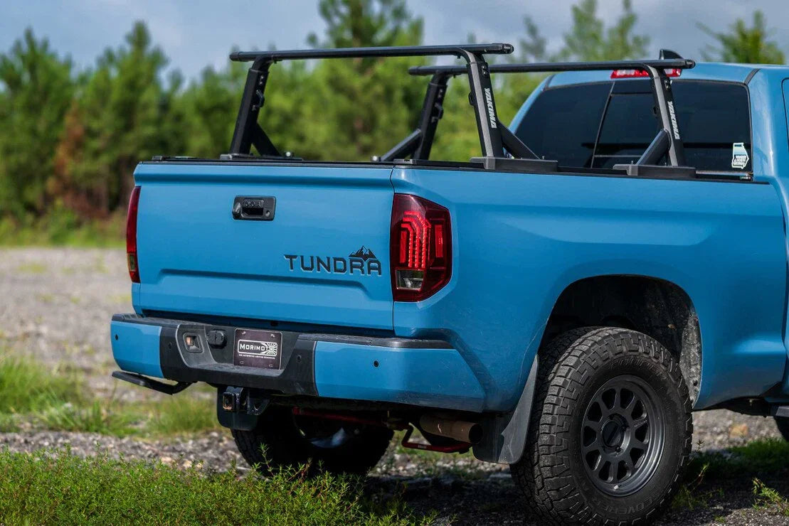 Blue Toyota Tundra with overlanding bed rack, off-road tires, outdoor setting