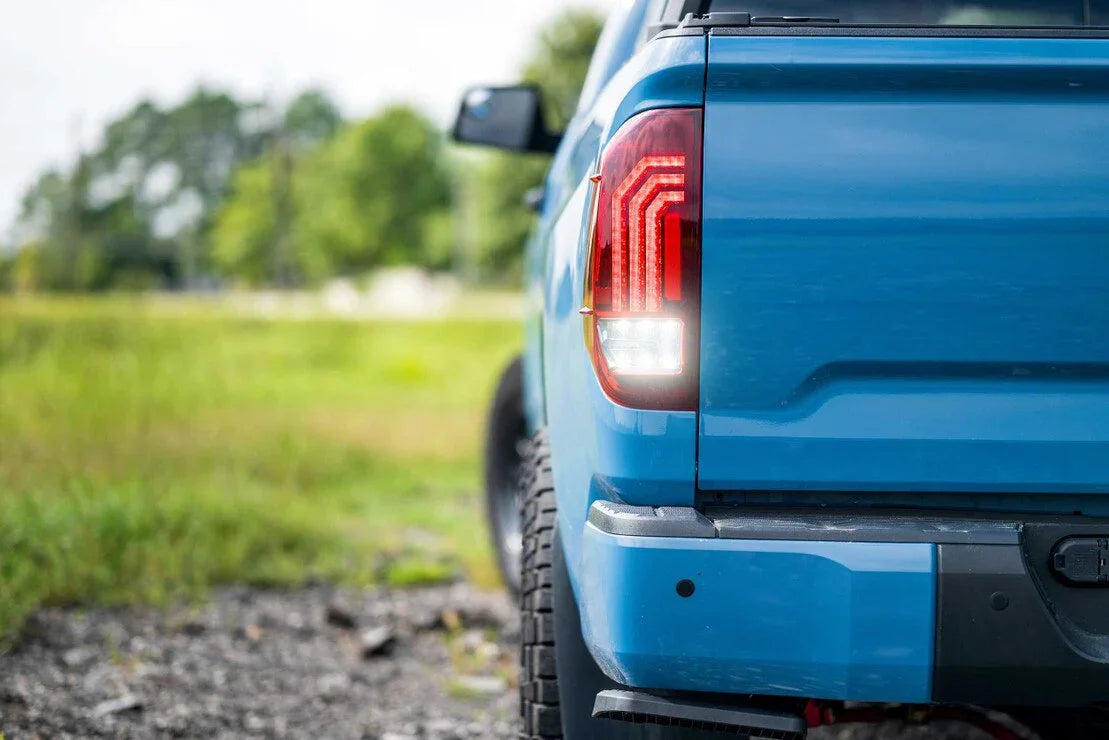 Close-up of blue Toyota Tundra rear with aftermarket LED tail lights in outdoor setting