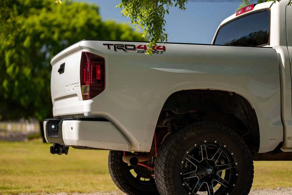 Toyota Tundra TRD 4x4 Sport rear closeup with off-road tires and custom wheels outdoors