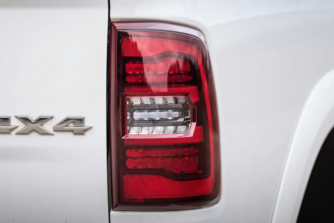 Close-up of a white pickup truck taillight and chrome 4x4 badge
