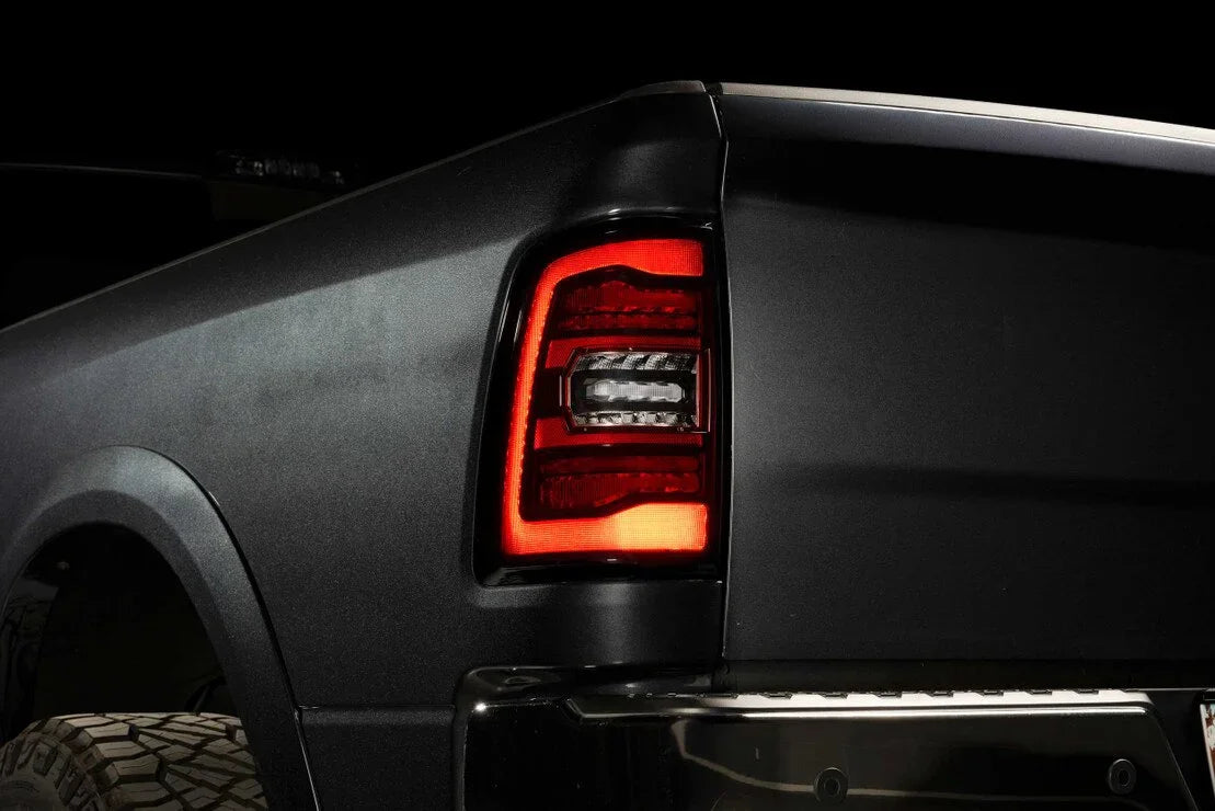 Close-up of a Ram 1500 Classic rear LED tail light and tire, dark background