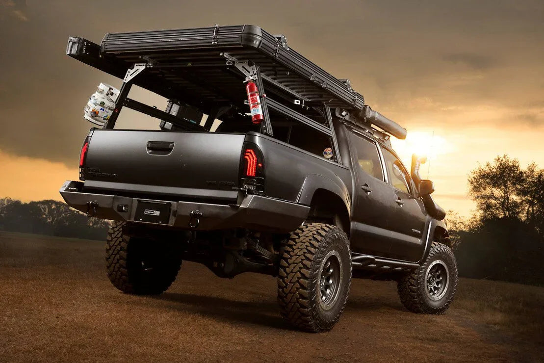 Lifted Toyota Tacoma overland truck with gear rack and off-road accessories at sunset