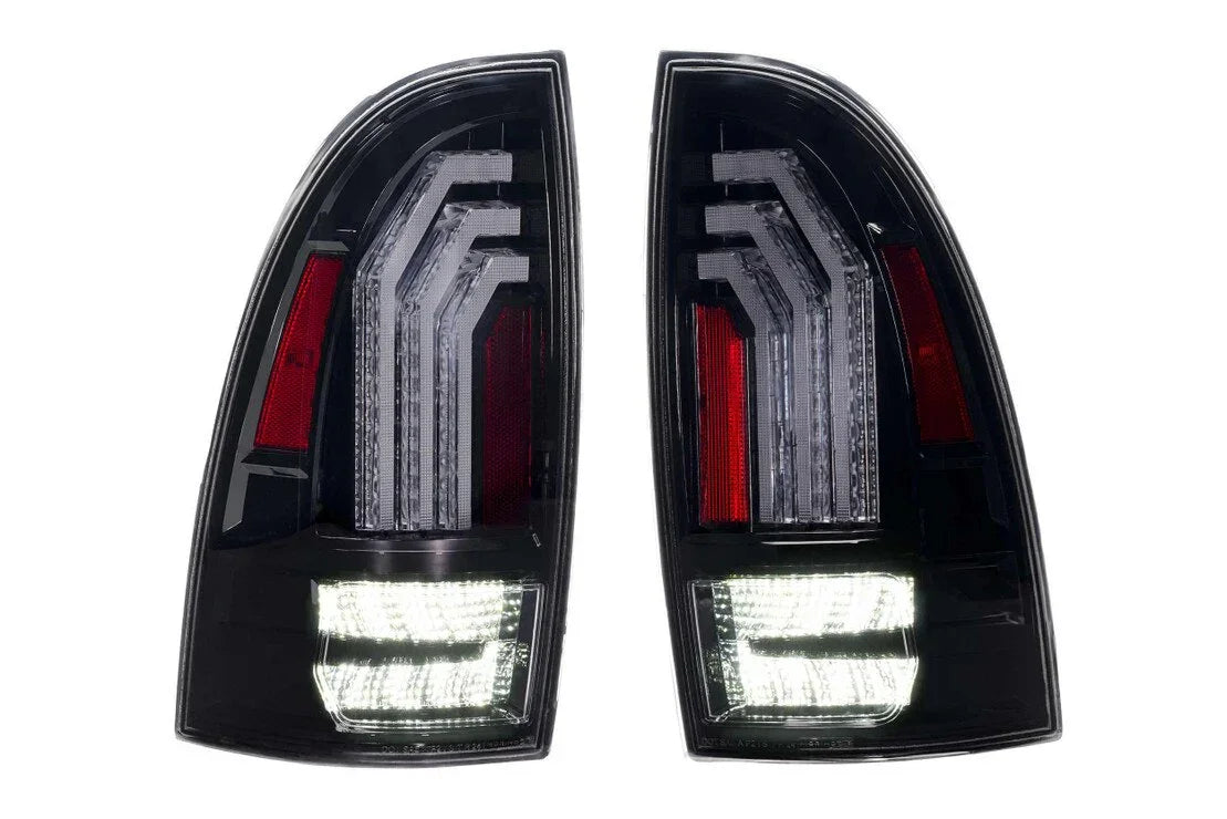 Pair of clear LED tail lights for Toyota Tacoma, modern black housing, illuminated design.