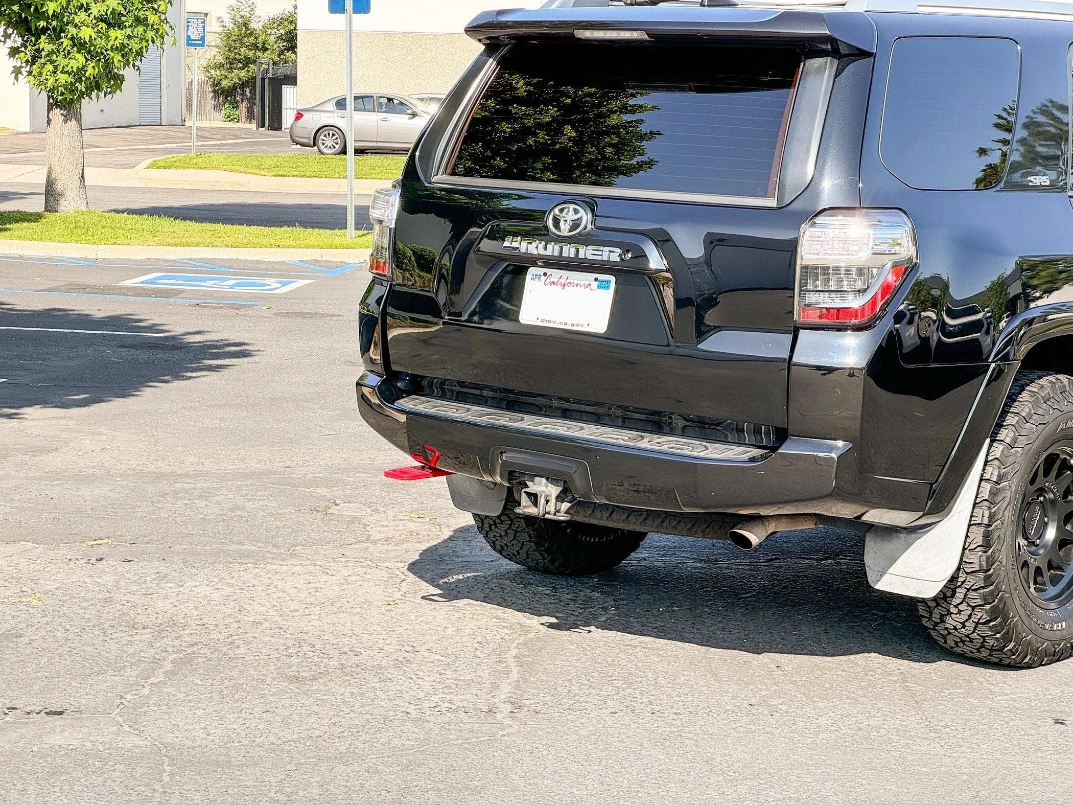 Toyota 4Runner with off-road rear hitch and red recovery shackle in parking lot