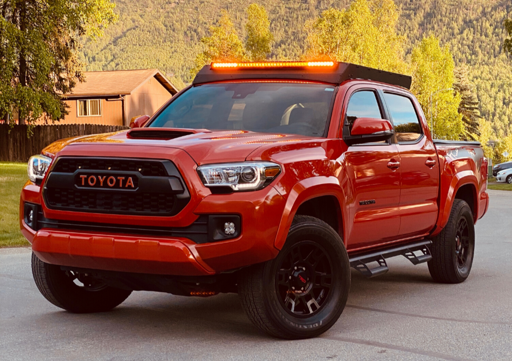 Toyota Tacoma truck with off-road accessories and roof LED light bar parked outdoors