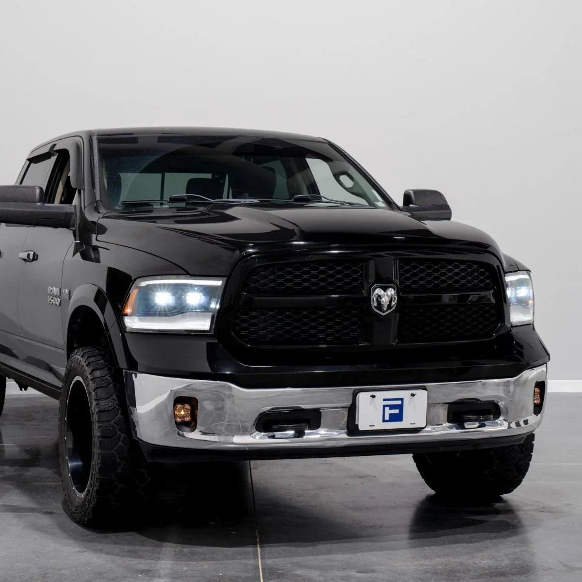 Black 2014 Ram 1500 with LED headlights, studio angle, chrome bumper, off-road ready