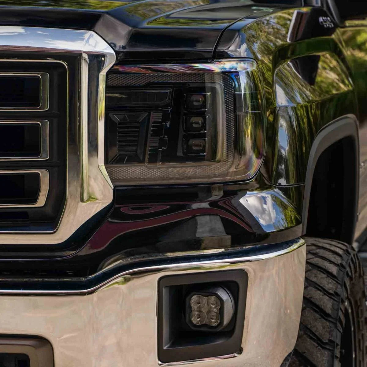 Close-up of smoked amber aftermarket headlight and grille on a 2015 GMC Sierra 1500 truck
