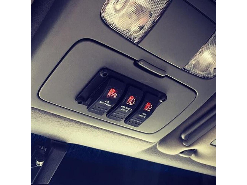 Overhead rocker switch panel installed in a Toyota Tacoma, with labeled accessory switches.