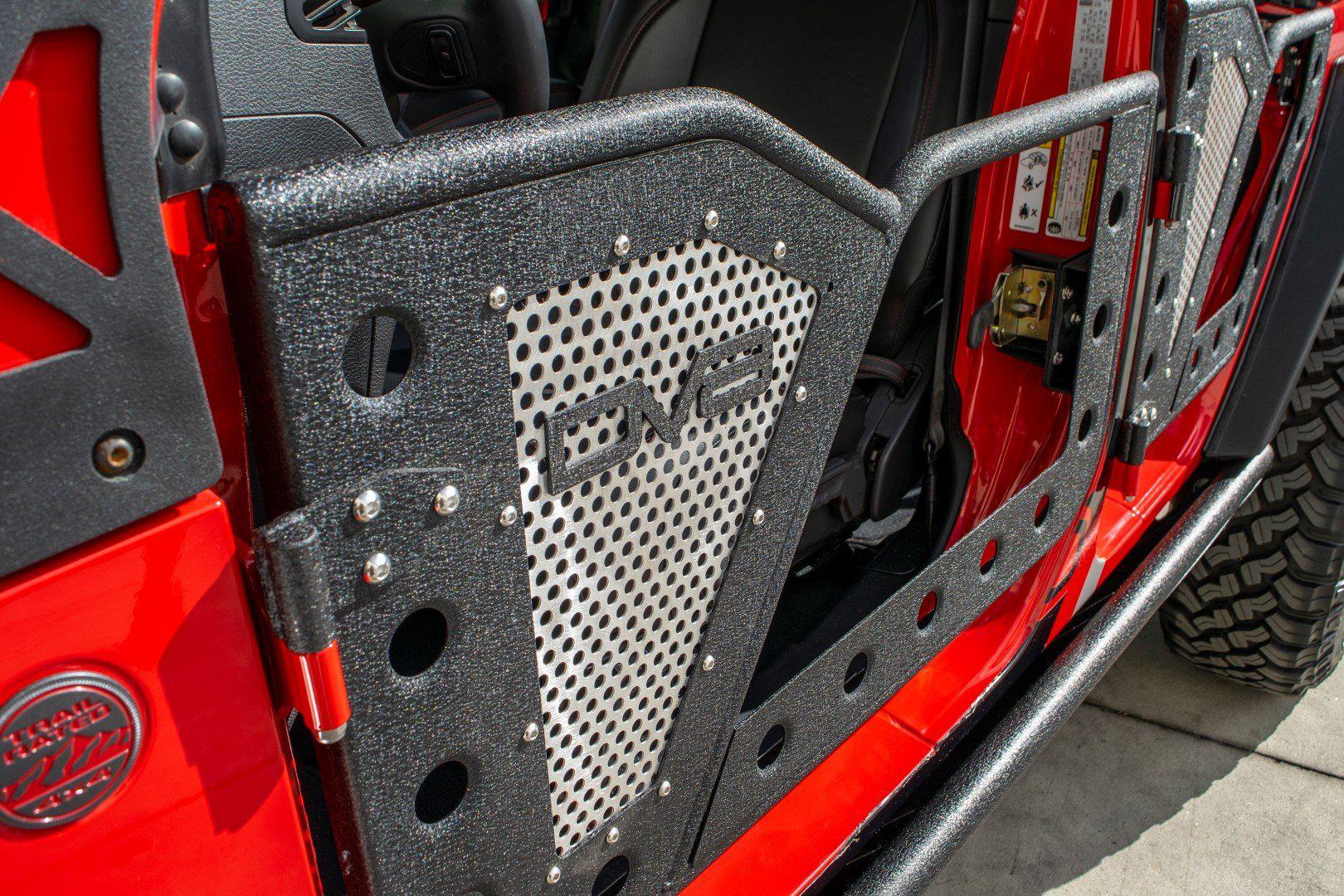 Steel rock door on red Jeep Wrangler, off-road accessory with DV8 logo, close-up view