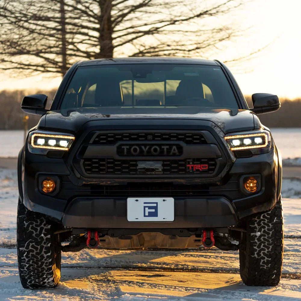 Toyota Tacoma with custom TRD front grille and dual color DRL headlights in snowy setting