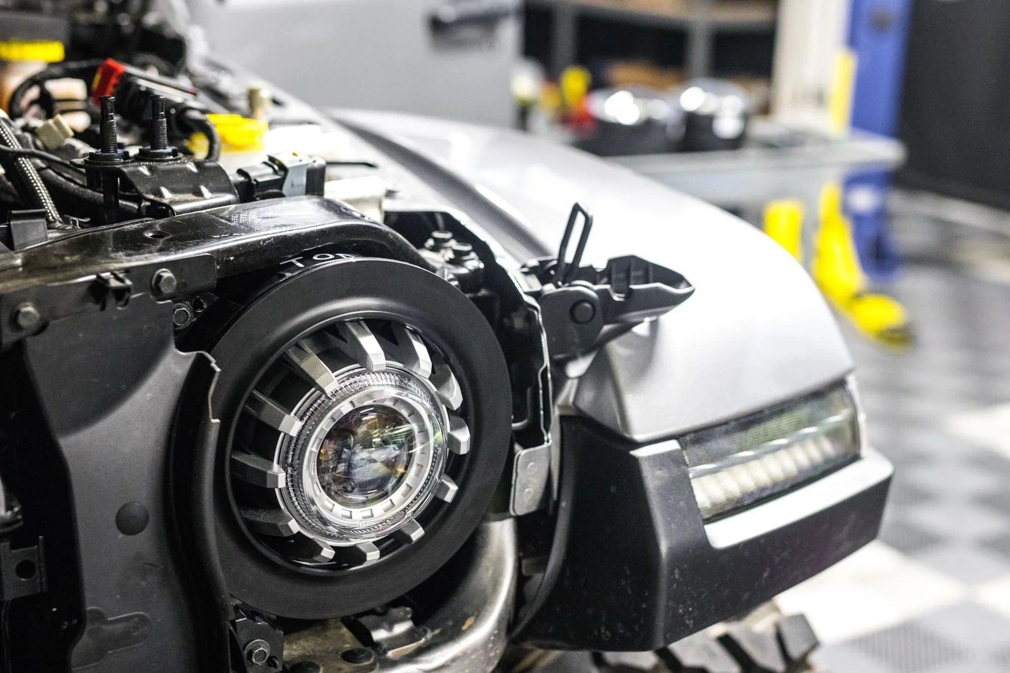 Close-up of Jeep Wrangler JL with 7-inch LED headlight adapter installed in garage
