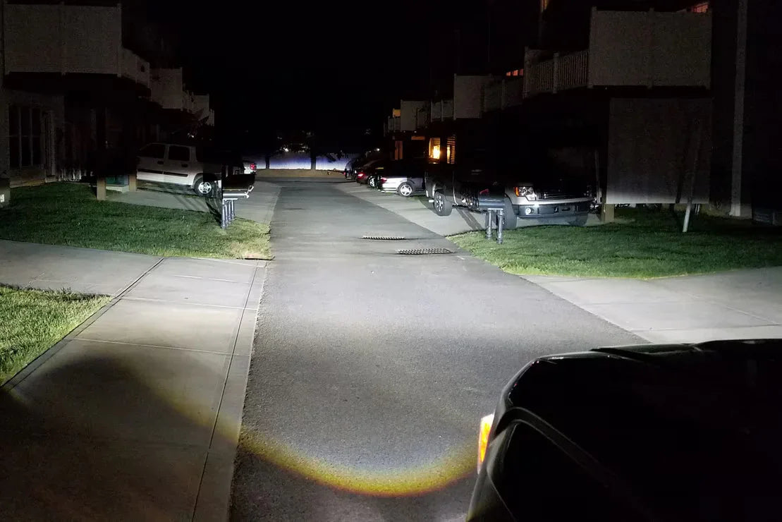 Bright LED headlights illuminating residential street at night, Jeep Wrangler perspective