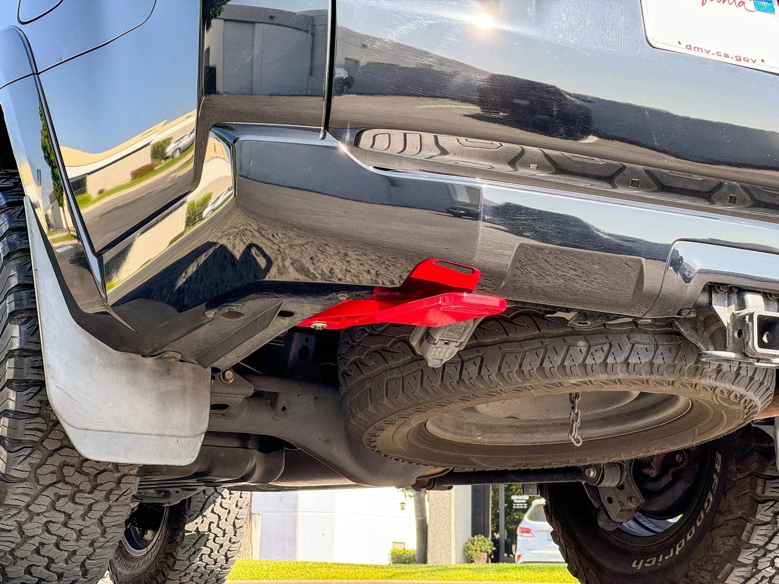 Red rear recovery point installed on an off-road Toyota truck with spare tire mount