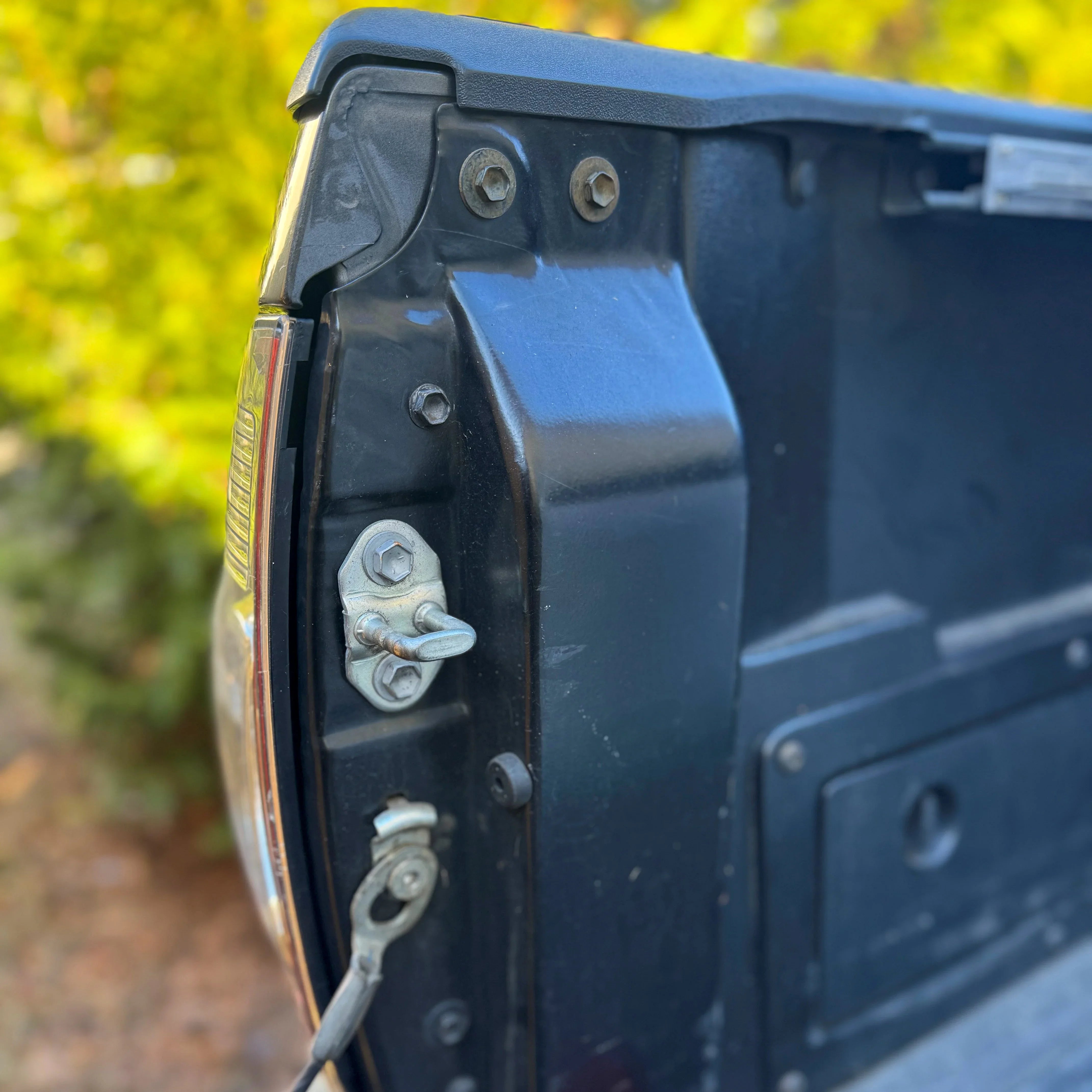 Close-up of second generation Toyota Tacoma tailgate hardware and latch mechanism