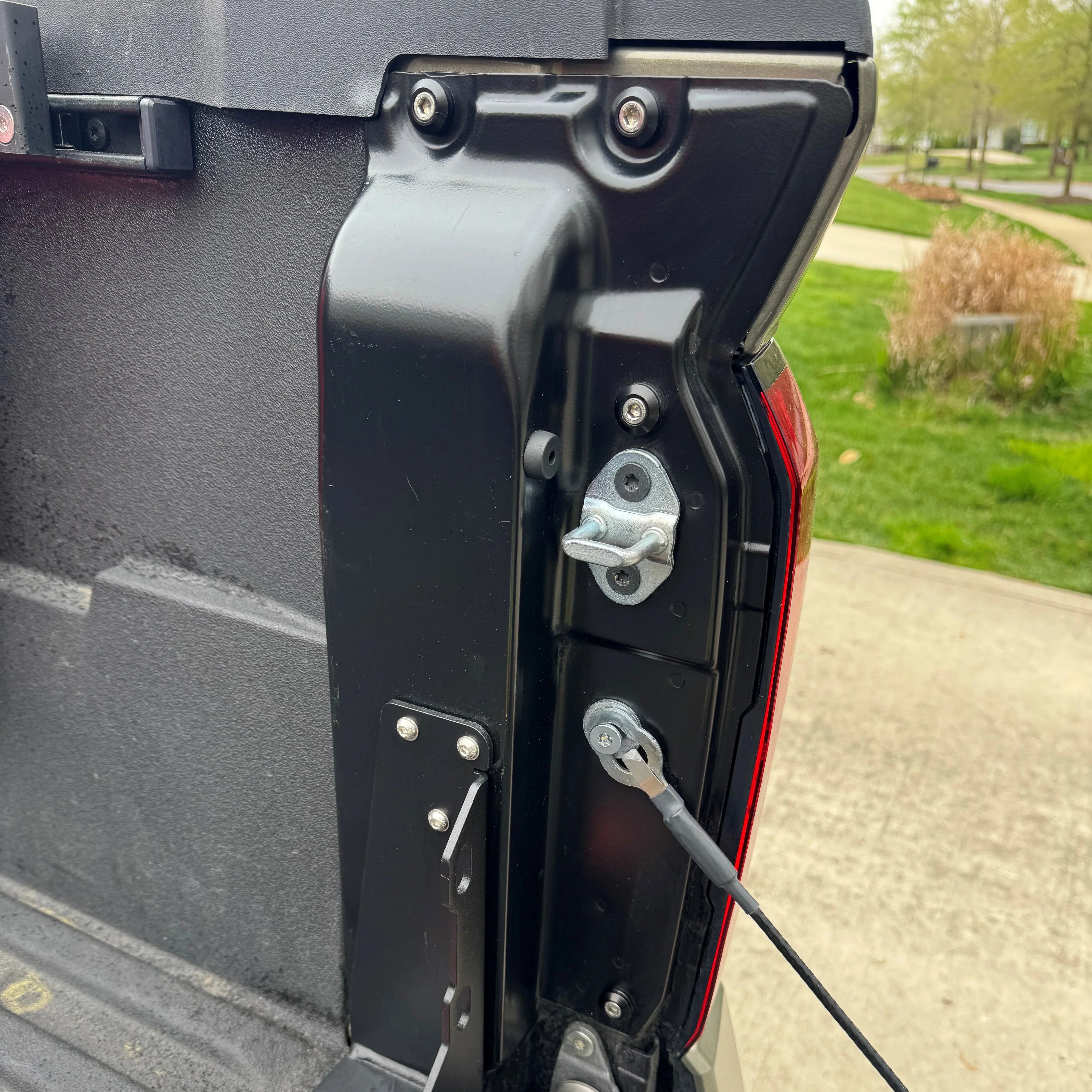 Close-up of 2nd gen Toyota Tacoma tailgate hardware and dress up bolts installed