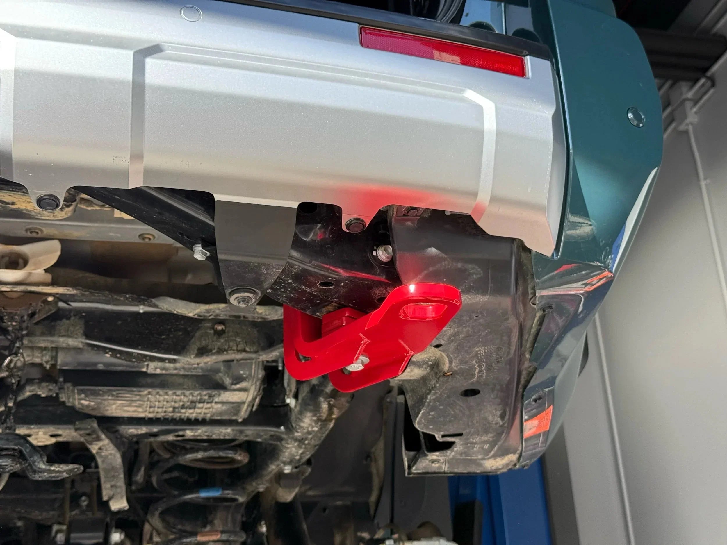 Red rear recovery point installed on off-road vehicle bumper, close-up view