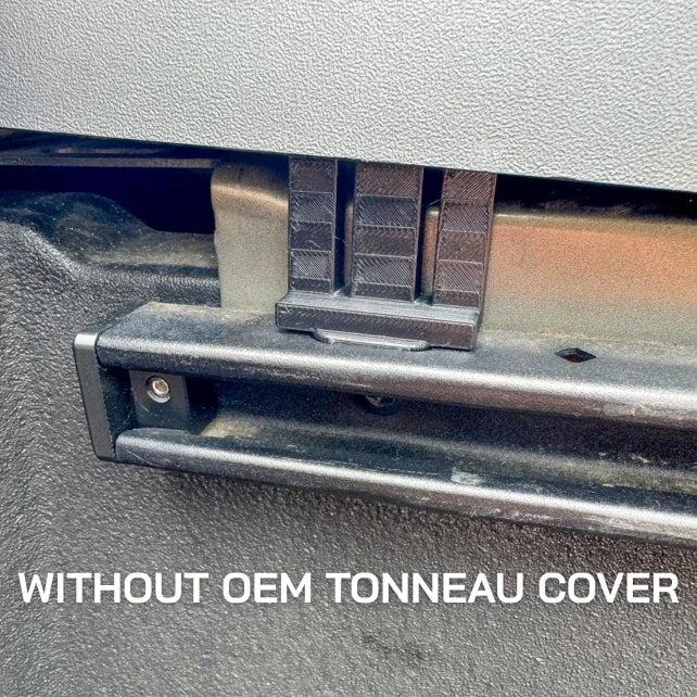 Close-up of truck bed rail system without OEM tonneau cover, showing mounting hardware.