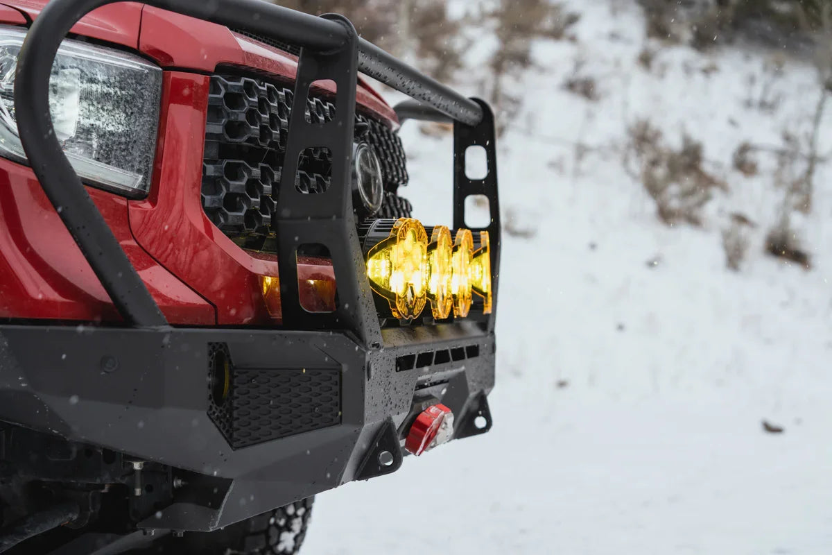 Toyota Tundra with off-road adventure front bumper and yellow LED lights in snowy setting